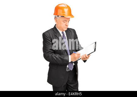 Reife Bauarbeiter Notizen auf einem Klemmbrett Stockfoto