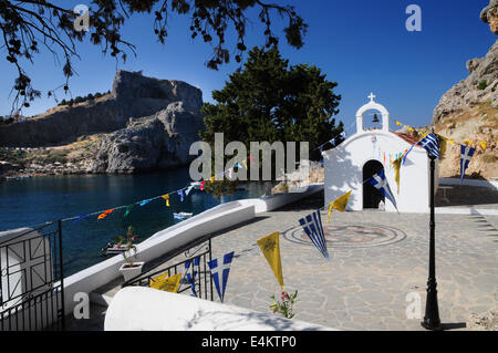 St-Paul-Kapelle mit Lindos Akropolis in St. Pauls Bay, Lindos, Rhodos, Griechenland Stockfoto