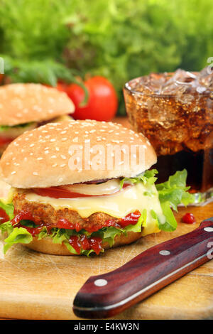 Hausgemachte Hamburger mit frischem Gemüse und Käse auf Holzbrett Stockfoto