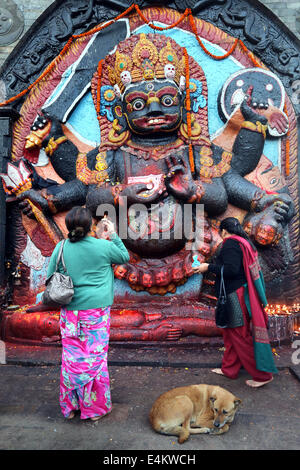 -Frauen beten vor Kala Bhairab Figur in Kathmandu Durbar Square, Nepal, Asien Stockfoto