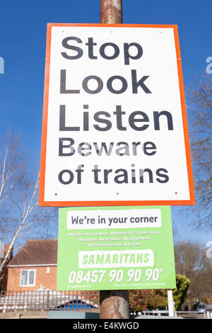 Stop sehen hören. Vorsicht vor Züge Zeichen mit den Samaritern Kontaktdaten unterhalb an einem Bahnübergang, Nottinghamshire, England, Großbritannien Stockfoto