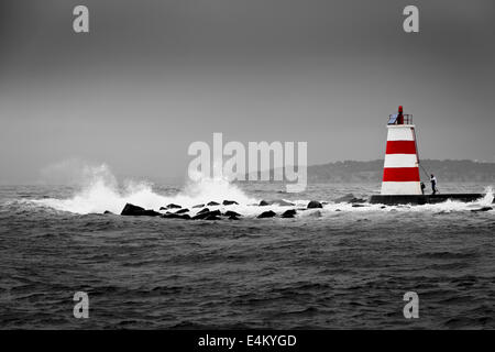 Portimao Wellenbrecher in schwarz und weiß mit Leuchtturm in Farbe Stockfoto