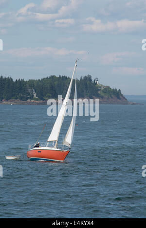 Rockland, Maine Penobscot Bay. Rote Segelboot vor Owls Head State Park, historische Owls Head Leuchtturm, ca. 1852. Stockfoto