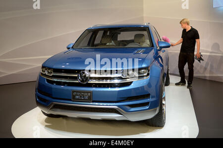 Wolfsburg, Deutschland. 14. Juli 2014. Ein Mitarbeiter Stäube des neuen SUV für den US-amerikanischen Markt "CrossBlue" in Wolfsburg, Deutschland, 14. Juli 2014. Volkswagen will seinen neue SUV "CrossBlue" im Werk in Chattanooga, USA zu bauen. VW seit Monaten in die weltweit am zweithäufigsten wichtig Automarkt ringt. Foto: PETER STEFFEN/DPA/Alamy Live-Nachrichten Stockfoto