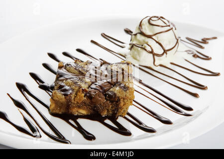 Schokoladen-Brownies mit Vanilleeis und Chocolat Sirup Stockfoto