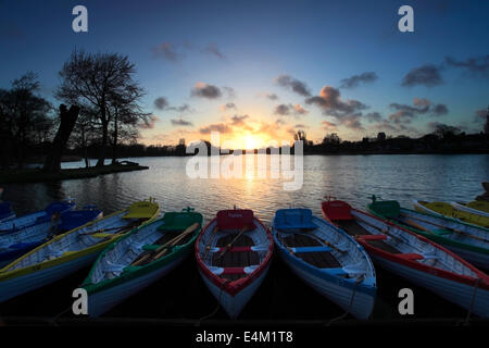 Sonnenuntergang über die bunte hölzerne Ruderboote zu mieten auf dem bloßen Thorpeness Village, Suffolk County, England Stockfoto