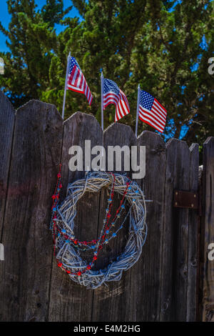 Drei amerikanische Flaggen & einen Kranz auf einem Zaun Tor in Santa Barbara County, Kalifornien feiern Unabhängigkeitstag Urlaub. Stockfoto