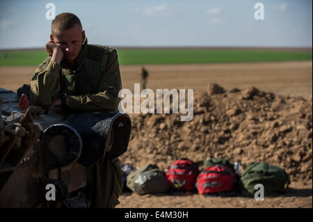 Grenze zum Gazastreifen, Operation Fels in der Brandung. 14. Juli 2014. Ein israelischer Soldat ruht neben einem 155mm M109 Dores Panzerhaubitze an einer Position im Süden Israels nahe der Grenze zu Gaza, am siebten Tag der Operation in der Brandung, am 14. Juli 2014. Israel begann Betrieb Fels in der Brandung am Dienstag um Raketenangriffe aus dem Gazastreifen zu beenden. Bildnachweis: Li Rui/Xinhua/Alamy Live-Nachrichten Stockfoto