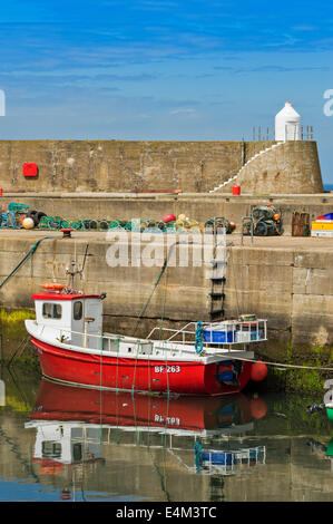 ROTES BOOT MIT HUMMER-TÖPFE AUF DER KAI FINDOCHTY HAFEN MORAY KÜSTE SCHOTTLAND Stockfoto