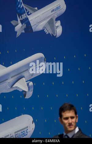 Ein Besucher unter eine Plakatwand von Beispielen der Airbus-Flugzeug-Flotte auf der Seite der Airbus corporate Chalet an der Farnborough Air Show, England. Airbus ist ein Flugzeugbau Division des Airbus-Konzerns (ehemals European Aeronautic Defence and Space Company). Sitz in Blagnac, Frankreich, einem Vorort von Toulouse, mit Produktions- und Fertigungsstätten vor allem in Frankreich, Deutschland, Spanien und das Vereinigte Königreich, produzierte die Firma 626 Flugzeuge im Jahr 2013. Stockfoto