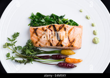 Gegrillter Lachs serviert mit grünen und Babykarotten. Stockfoto