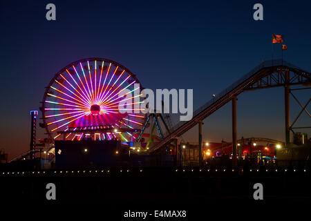 Riesenrad und Achterbahn in der Abenddämmerung, Pacific Park, Santa Monica Pier, Santa Monica, Los Angeles, Kalifornien, USA Stockfoto