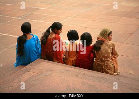 Fünf indische Frauen sitzen zusammen vor einer Moschee in Delhi, Indien Stockfoto