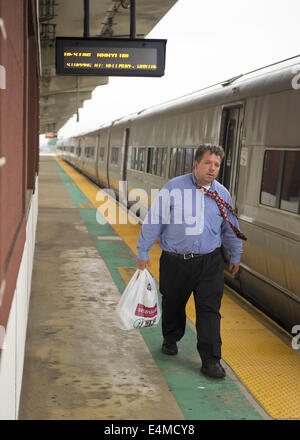 Merrick, New York, USA. 14. Juli 2014. Im Feierabendverkehr Pendler mit Krawatte fliegen fährt Zug und Spaziergänge auf erhöhten Plattform von Merrick Bahnhof der Filiale in Babylon, nachdem MTA Metropolitan Transit Authority und Long Island Rail Road Union spricht Deadlock mit Potenzial LIRR schlagen sich abzeichnende nur wenige Tage vor. © Ann Parry/ZUMA Draht/Alamy Live-Nachrichten Stockfoto