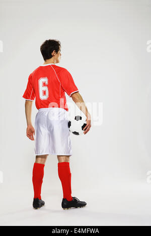 Football-Spieler in einem weißen und roten uniform steht vor weißem Hintergrund Stockfoto