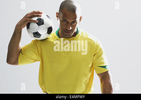 Football-Spieler in einem gelben uniform steht vor weißem Hintergrund Stockfoto