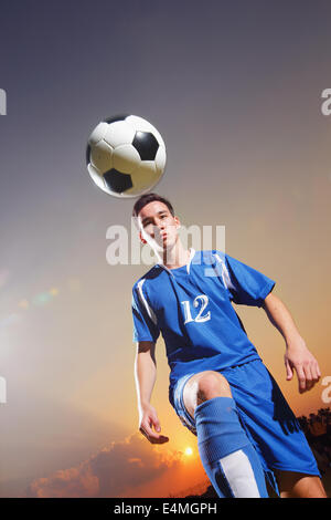 Football-Spieler in einer blauen Uniform Kugel anheben Stockfoto