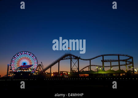 Riesenrad und Achterbahn in der Abenddämmerung, Pacific Park, Santa Monica Pier, Santa Monica, Los Angeles, Kalifornien, USA Stockfoto