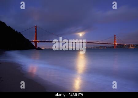 Ein Vollmond steigt über San Francisco und die Golden Gate Bridge von Kirby Bucht in die Marin Headlands. Stockfoto