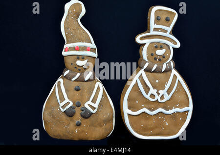 Lebkuchen und zwei Figuren, Mann Schneemann, Nahaufnahme, auf schwarzem Hintergrund isoliert Stockfoto