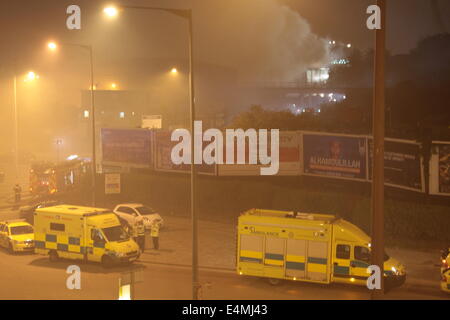 London, UK. 15. Juli 2014. Einige 70 Feuerwehrleute aus ganz London aufgerufen, um ein Feuer in einem Abfallzwischenlager auf enge Skarabäus, Canning Town East London zu bewältigen. Crews aus so weit weg wie Tooting hießen die Szene auf der Glut eingehen, die mehrere hundert Tonnen Reststoffen beteiligt. Dicker Rauch bauschte aus das Feuer führte zu LFB Warnung Anwohner, Türen und Fenster geschlossen zu halten. Es ist noch nicht bekannt, wenn die Schließung der von Silvertown Feuerwache erbittert Blaze schließen, da Besatzungen mussten aus weiter zu dem Vorfall zu reisen. Bildnachweis: HOT SHOTS/Alamy Li Stockfoto