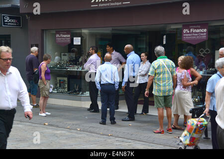 Gibraltar 15. Juli 2014 - Shop-Besitzer und Arbeiter von Türen über Main Street stand warten macht im Zentrum Stadt wiederhergestellt werden. Das britische Gebiet Gibraltars hatte häufige Stromausfälle macht, da eine Explosion im wesentlichen elektrische Kraftwerk seine Generatoren schwer beschädigt sah. Bildnachweis: Stephen Ignacio/Alamy Live-Nachrichten Stockfoto