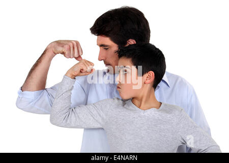 Vater und Sohn ihre Muskeln zu vergleichen Stockfoto