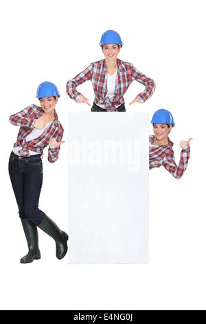 Weibliche Baumeister stand mit leeren poster Stockfoto