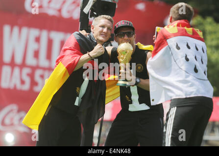 Bastian Schweinsteiger (L) und Lukas Podolski Deutschlands jubeln und feiern während der Begrüßungsempfang für Deutschlands Fußball-Nationalmannschaft vor dem Brandenburger Tor, Berlin, Deutschland, 15. Juli 2014. Die deutsche Mannschaft gewann Brasilien 2014 FIFA Soccer World Cup-Finale gegen Argentinien mit 1: 0 am 13. Juli 2014, die WM Titel zum vierten Mal nach 1954, 1974 und 1990. Stockfoto