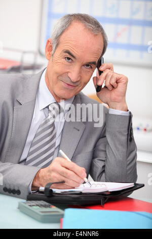 Älteren Geschäftsmann mit einem Handy Stockfoto