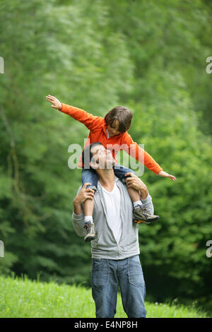 Kleiner Junge saß auf Vaters Schultern Stockfoto