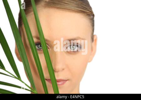 Frau versteckt sich hinter einem Farn Stockfoto