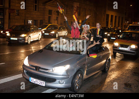 Wiesbaden, Deutschland. 14. Juli 2014. Deutschland gewinnt das FIFA WM 2014. Menschen in ihren Autos und auf der Straße, jubeln und feiern in der Innenstadt von Wiesbaden nach Deutschlands Sieg über Argentinien im Endspiel. Bewegungsunschärfe. Bildnachweis: Oliver Kessler/Alamy Live-Nachrichten Stockfoto