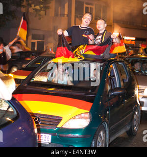 Wiesbaden, Deutschland. 14. Juli 2014. Deutschland gewinnt das FIFA WM 2014. Menschen in ihren Autos und auf der Straße, jubeln und feiern in der Innenstadt von Wiesbaden nach Deutschlands Sieg über Argentinien im Endspiel. Bewegungsunschärfe. Bildnachweis: Oliver Kessler/Alamy Live-Nachrichten Stockfoto