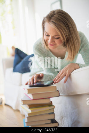 Frau auf dem Sofa liegend und mit digital-Tablette Stockfoto