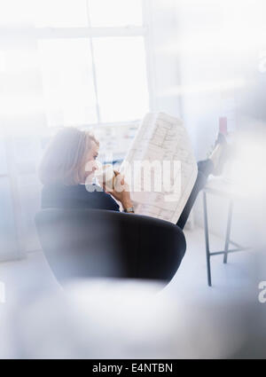 Business-Frau betrachten Blaupause im Büro Stockfoto