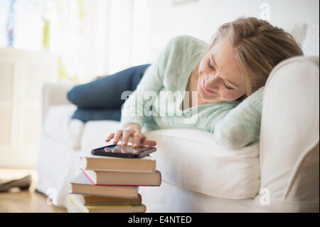 Frau auf dem Sofa liegend und mit digital-Tablette Stockfoto