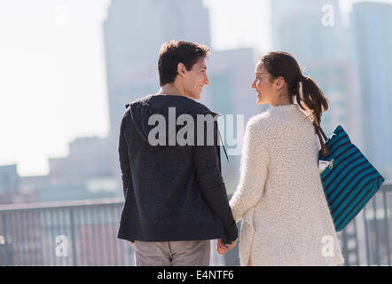 Junges Paar gehen, Gebäude im Hintergrund Stockfoto