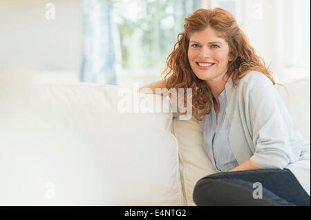 Frau sitzt auf dem sofa Stockfoto