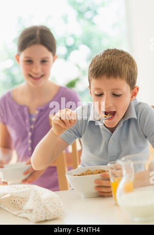 Jungen und Mädchen (8-9, 10-11) Getreide essen Stockfoto