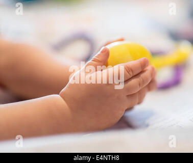 Händen des Mädchens (6-11 Monate) hält Spielzeug Stockfoto