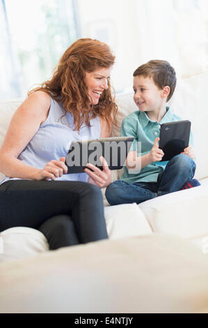 Mutter und Sohn (6-7) mit digitalen Tabletten Stockfoto