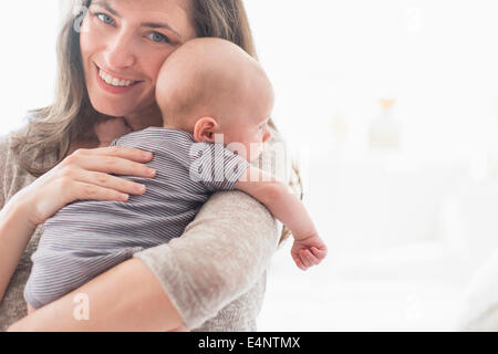 Porträt von lächelnden Mutter Baby Boy (2-5 Monate) im Arm halten Stockfoto