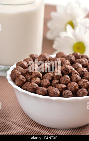 Müsli Schoko Kugeln in Schüssel und ein Glas Milch Stockfoto