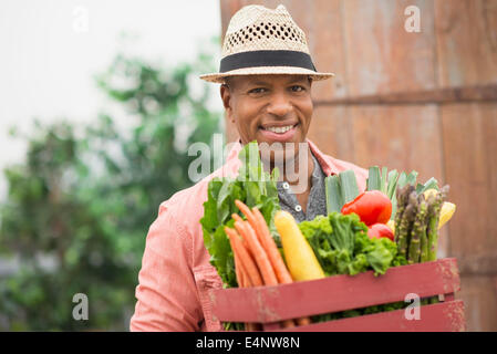 Portrait der Mann mit der Kiste voll mit frischem Gemüse Stockfoto