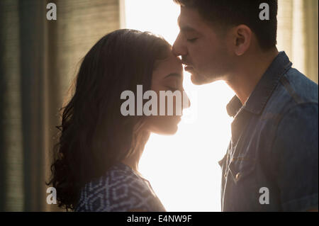 Junges Paar küssen im Sonnenlicht Stockfoto