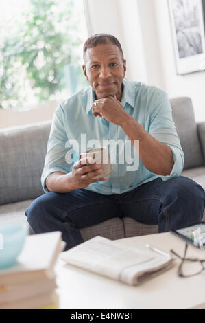 Portrait der Mann sitzt auf dem Sofa zu Hause Stockfoto