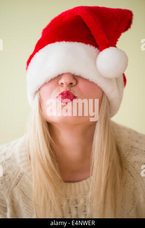Studioaufnahme von Frau trägt Weihnachtsmütze und kräuseln Stockfoto