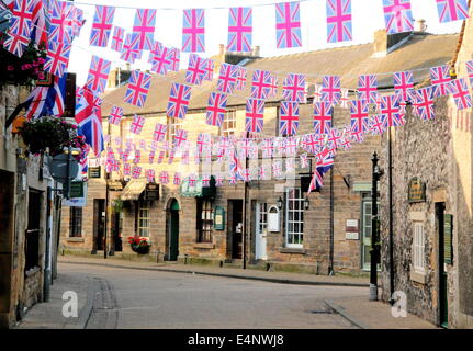 Union Jack Bunting fliegen über eine Einkaufsstraße in Bakewell Stadtzentrum; eine historische englische Marktstadt - Sommer, UK Stockfoto