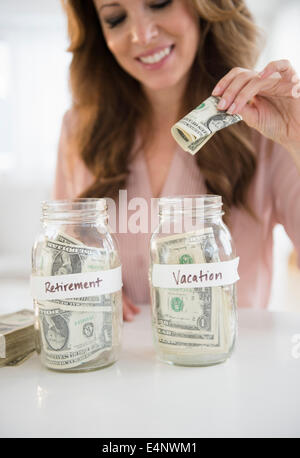 Frau, Geld in Glas Stockfoto